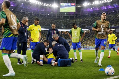 FIFA Medical Team Assesses Injured Player at Soccer Match
