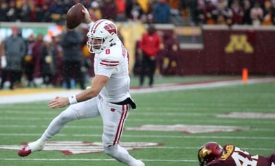 Wisconsin senior quarterback Tanner Mordecai evades Minnesota linebacker Cody Lindenberg on Saturday at Huntington Bank Stadium in Minneapolis. Brandon Berg